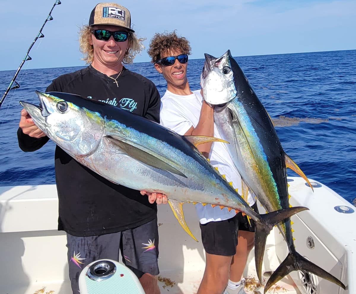 two anglers hold yellowfin tuna caught across the Gulf Stream off Florida East Coast