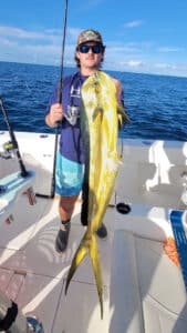 an angler holding a dolphin, aka mahi mahi or dorado
