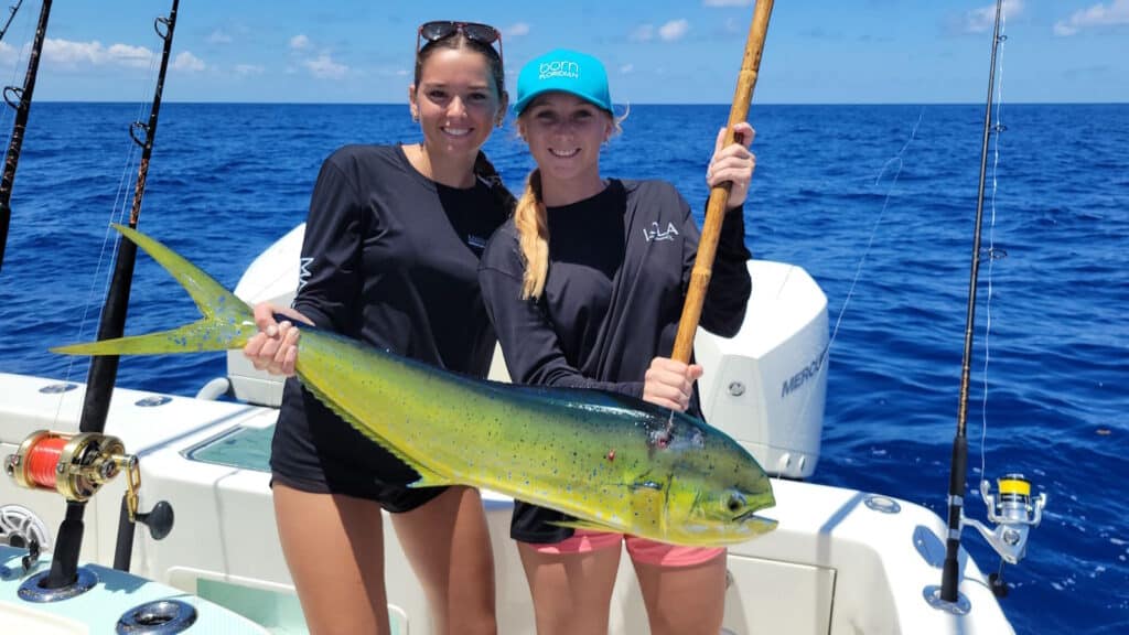 two anglers holding a dolphinfish, aka dorado or mahi mahi