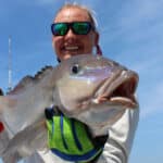 lady angler holds a blueline tilefish close to camera