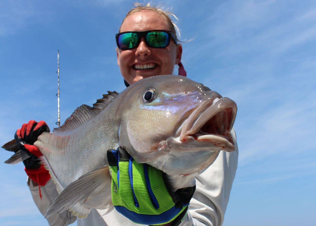 lady angler holds a blueline tilefish close to camera