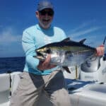 man holds blackfin tuna caught during offshore fishing trip