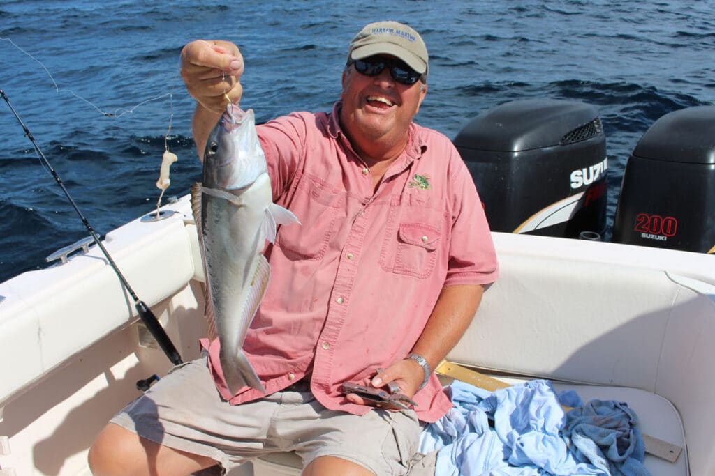 angler poses with a blueline tilefish he caught using a top-and-bottom fishing rig with cut squid.